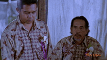 two men are standing next to each other with a man laksa logo behind them
