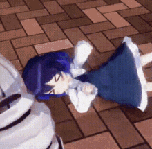 a girl in a blue dress is laying on a brick sidewalk .