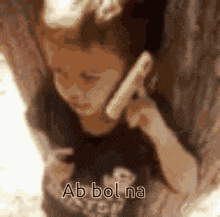 a child is talking on a cell phone and the words ab bol na are on the bottom of the image