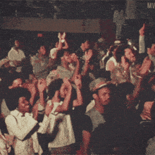 a crowd of people with their hands in the air and the word mw on the bottom right