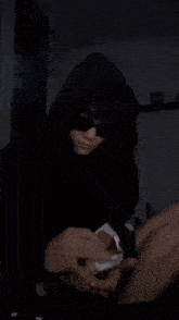 a person wearing a black hoodie is holding a piece of paper that says ' snickers ' on it