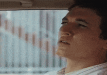 a man is looking out the window of a car .