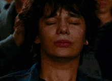 a close up of a man 's face with a tear running down his cheek