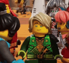 a group of lego figures are standing next to each other in a room .