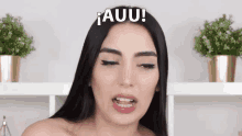 a woman is making a funny face with the word auu written above her head