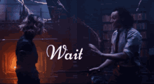 a man and a woman are standing next to each other and the words wait are on the screen