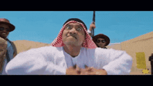 a man in a white shirt and red and white head scarf making a funny face