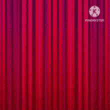 a close up of a red curtain with a logo on it