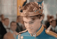 a young man wearing a crown and a blue uniform is standing in front of a crowd .