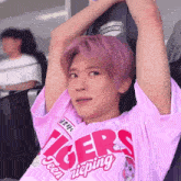 a young man with pink hair is wearing a pink tigers shirt