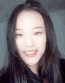 a close up of a woman with long hair smiling .