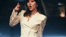 a woman in a white jacket has the letter m above her head