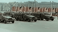 a row of military vehicles are driving down the street