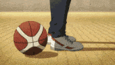 a person is standing next to a basketball on the floor