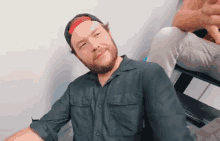 a man with a beard wearing a black shirt and a baseball cap