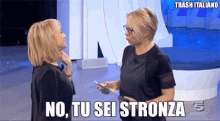 two women standing next to each other with the words " no tu sei stronza " written above them