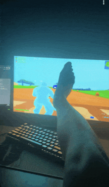 a person 's foot is resting on a keyboard in front of a computer screen
