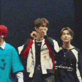 a group of young men are standing next to each other on a stage . one of the men has red hair .