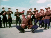 a group of men in uniforms are dancing together
