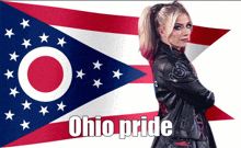 a woman in a leather jacket stands in front of an ohio pride flag