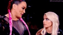 two women are standing next to each other in a dark room .