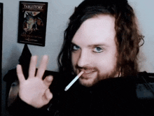 a man with long hair and a beard holds a cigarette in his mouth in front of a tablestory poster