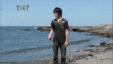 a man standing on a beach with the time of 7:47 on the bottom
