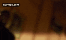 a blurry picture of a person standing in a dark room with the words kulfyapp.com written on the bottom .