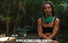 a woman with a green scarf around her neck is sitting in the woods and says ana 28