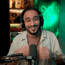 a man wearing headphones stands in front of a microphone