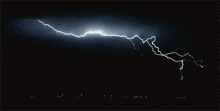 a lightning bolt strikes the ground in the night sky