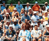 a group of people sitting on bleachers with one man wearing a t-shirt that says ' i love you '