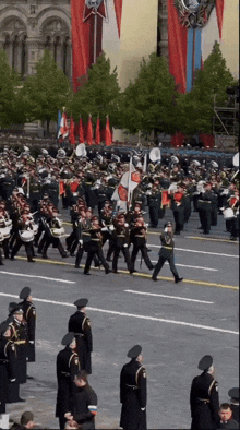 a marching band is marching down a street in front of a building with a medal on it