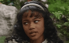 a close up of a young girl wearing a headband looking at the camera .