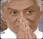 a close up of a person covering their nose with their hands