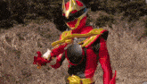 a red and yellow superhero is holding a sword in his hand .