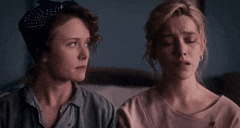 two women are sitting next to each other with their eyes closed and looking at each other .