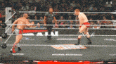 two wrestlers are in a wrestling ring with a sign that says ' ain ' on it