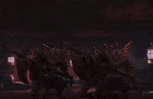 a group of monsters with wings are standing in a dark room .