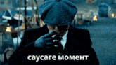 a man in a suit and hat smoking a cigarette with the words sausage moment in white letters