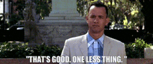 a man in a suit and tie is sitting on a bench and says that 's good one less thing .