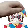 a person is holding a stuffed toy with a hat on it .