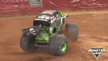 a monster jam truck is driving on a dirt road