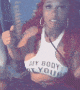 a woman with red hair is wearing a white crop top that says my body is yours .