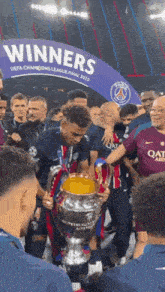 a soccer player holds a trophy in front of a banner that says " winners "