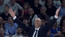 a man in a suit and tie with his arms in the air