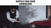 a man is holding a hammer in front of a red car with the words " happiest man from birmingham " below him