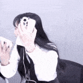 a girl with long black hair is holding a white phone