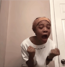 a woman in a white shirt is making a funny face with her mouth open