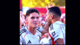 two soccer players are giving each other a high five and one has the letter b on his jersey